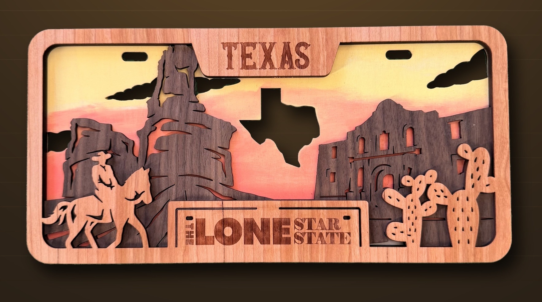 Multi-layer laser-cut Texas Lone Star wood art with cowboy and Alamo scene in warm sunset tones