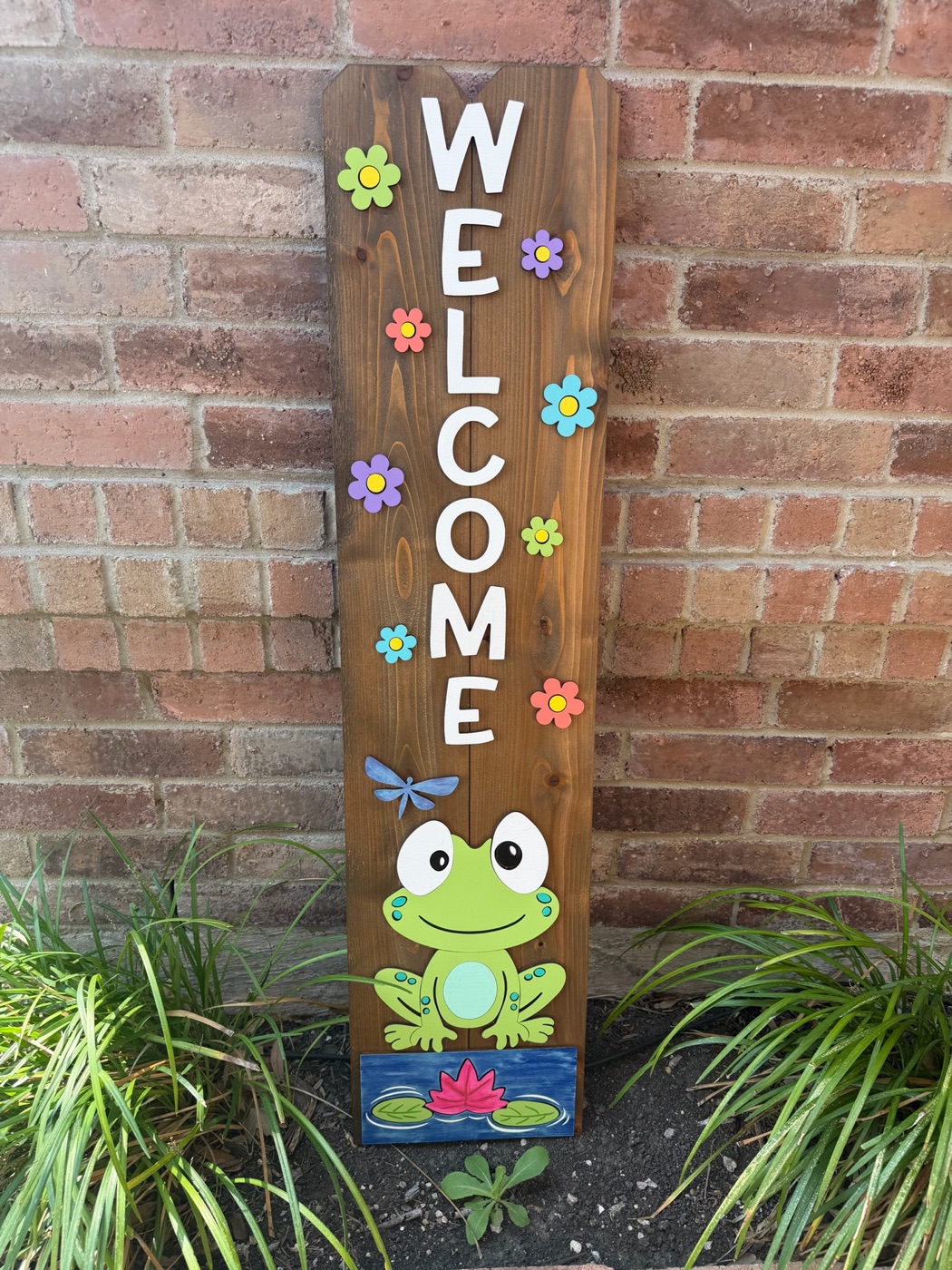 Handpainted frog Welcome porch leaner sign on dark-stained cedar board with colorful flowers